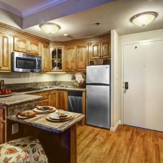 A cozy kitchen with wooden cabinets, a small dining area, and modern appliances.