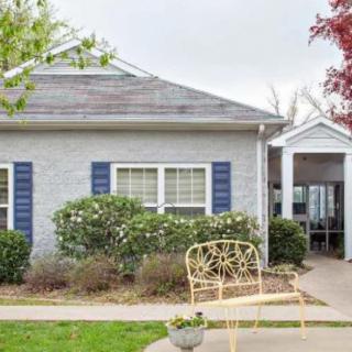 A cozy house with a yellow bench in the garden.