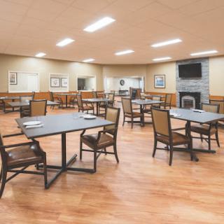 A spacious and well-lit dining area featuring multiple tables and chairs.