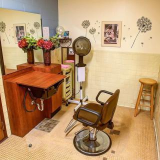 Cozy hair salon setup with a barber chair, mirror, and decor.