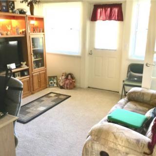 A cozy living room with a sofa, television, and entertainment center.