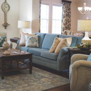 A cozy living room with a blue sofa, elegant armchairs, and stylish decor.