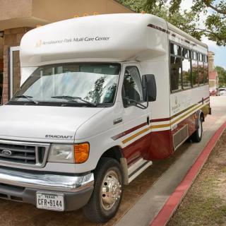 A parked shuttle bus outside a building.