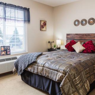 Cozy and well-decorated bedroom with a large bed, pillows, a window, and stylish decor.