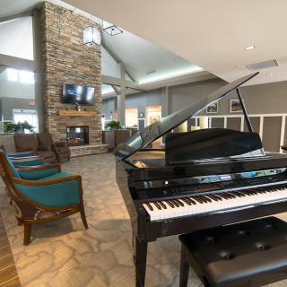 A modern living room featuring a grand piano and a cozy fireplace.
