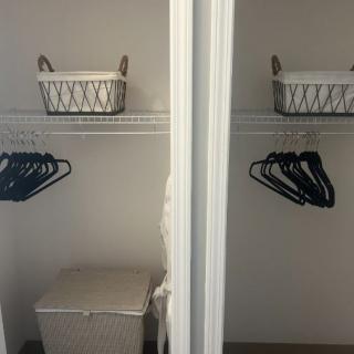 An empty closet with hangers and storage baskets.