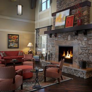 A cozy living room with a stone fireplace and comfortable seating.
