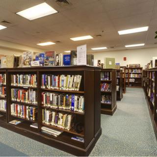 Interior of a library with rows of bookshelves filled with books.
