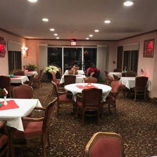 A cozy restaurant interior with elegantly set dining tables and ambient lighting.