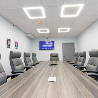 A modern conference room equipped with ergonomic chairs and a spacious meeting table, ideal for business discussions.