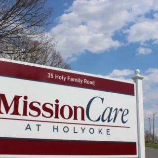 Sign for MissionCare at Holyoke against a blue sky backdrop.