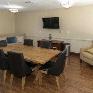 A modern conference room equipped with a meeting table, chairs, and a wall-mounted television.