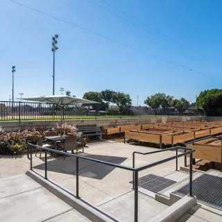 A view of an outdoor sports facility featuring a well-maintained field and landscaped areas.