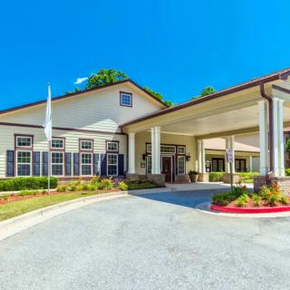 An exterior view of a building with a covered entrance and landscaped surroundings.