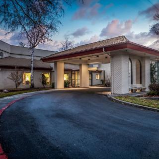 Evening view of a building entrance with a driveway.