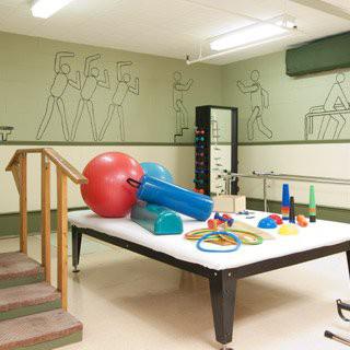 A physical therapy room equipped with various exercise tools and a set of stairs.