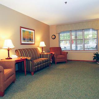A cozy living room with comfortable seating, soft lighting, and a large window.