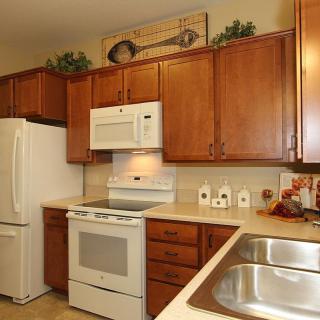 A cozy kitchen featuring wooden cabinets and white appliances.