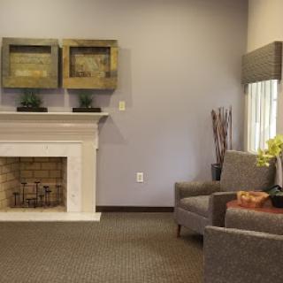 A stylish and cozy living room featuring a modern fireplace and comfortable seating.