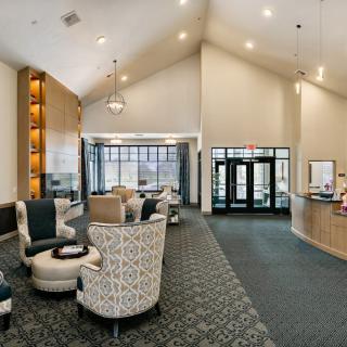 A spacious and well-lit lobby with comfortable seating and a reception desk.