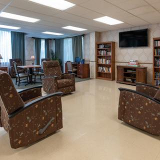 A cozy lounge area featuring comfortable recliners and bookshelves, ideal for relaxation and social interaction.