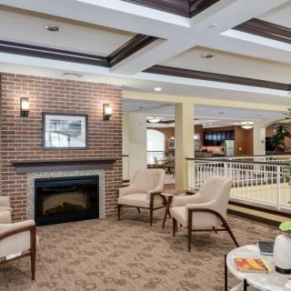 A modern lounge area featuring a cozy fireplace and comfortable seating.