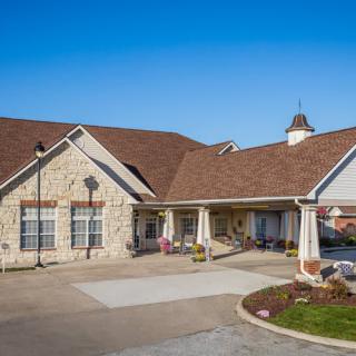 A residential building with a brick exterior and driveway under a clear blue sky.