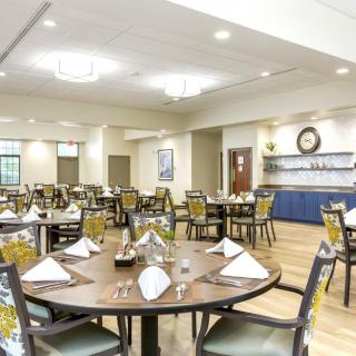 An elegantly set dining room with neatly arranged tables and chairs, ready for guests.