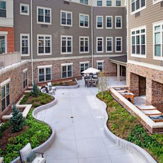 A modern residential courtyard with landscaping and outdoor seating areas.