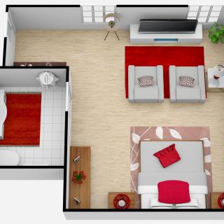 A modern and cozy open-concept floor plan featuring a bedroom and living area with red accents.