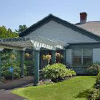 A charming house with a lush garden and pergola.