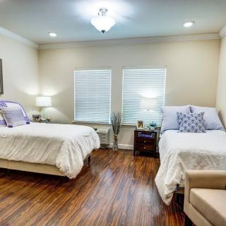 A cozy bedroom with twin beds, wooden flooring, and soft lighting.