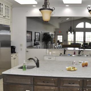 A modern kitchen with a large island and elegant lighting.