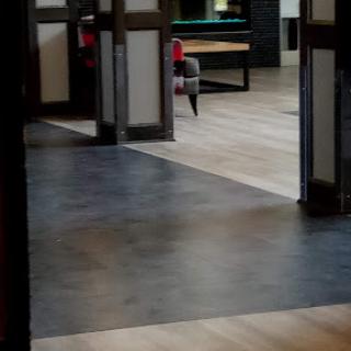 A modern interior showcasing a transition between different flooring styles in a spacious living area.