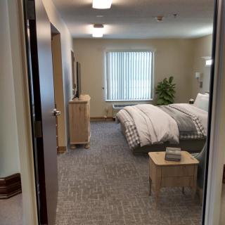 A cozy and minimalist bedroom interior with a neatly made bed and simple furniture.