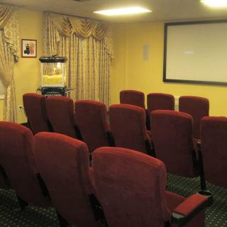 A small home theater room with red seating and a popcorn machine.