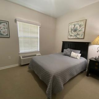 A cozy bedroom with a neatly made bed and soft lighting.