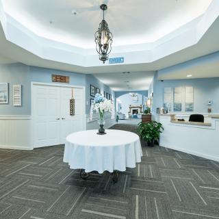 A well-lit lobby with a central table and elegant decor.