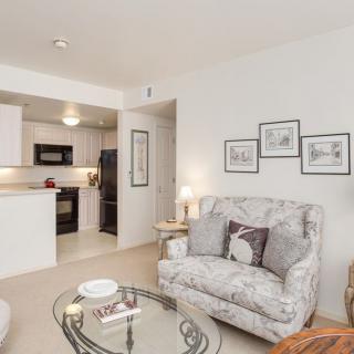 A cozy living room with a view of the kitchen, featuring comfortable seating and stylish decor.