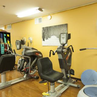 A gym room with various exercise machines and equipment.