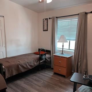 A cozy and simple bedroom with two beds, minimal decor, and a warm ambiance.