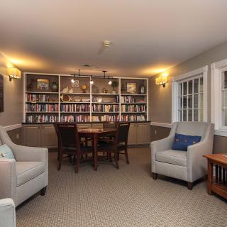Cozy library room with bookshelves and comfortable seating.