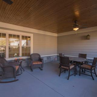 A cozy, covered patio with comfortable seating and a dining table.