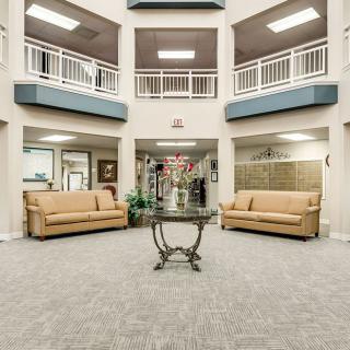A spacious lobby area featuring two sofas and a central table with floral decoration.