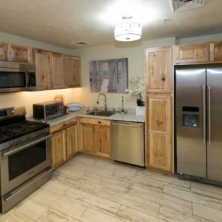 A modern kitchen featuring stainless steel appliances and wooden cabinets.