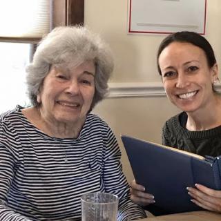 A joyful moment shared between an elderly woman and a younger companion, both smiling at the camera.
