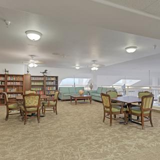 A cozy library reading area with bookshelves and seating arrangements.