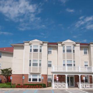 A three-story hotel building with a sunny sky above.