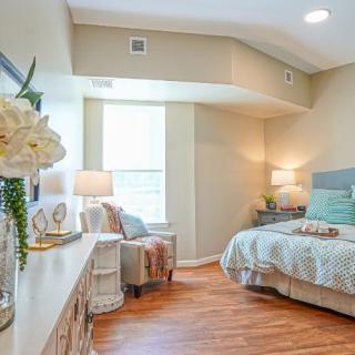 A cozy and bright bedroom with modern decor, featuring hardwood floors and soft lighting.