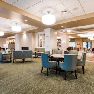 A spacious and modern lounge area featuring a variety of seating options and stylish lighting.